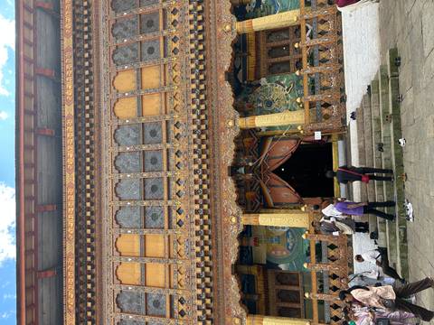       A richly decorated Buddhist temple with visitors.
  