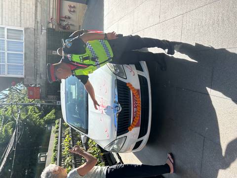A police officer pointing at a decorated car.