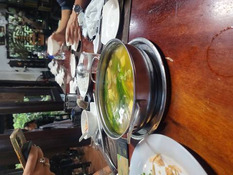 Hot pot on a dining table with dishes around it.