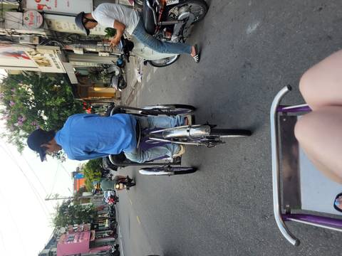 Person riding a rickshaw on a busy street.