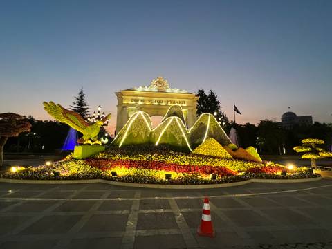       An illuminated floral sculpture at dusk.
  