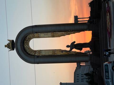       Statue in silhouette against a colorful sunset sky.
  