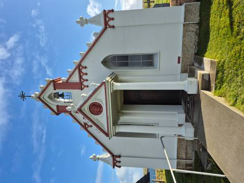       Small white chapel under a clear blue sky.
  