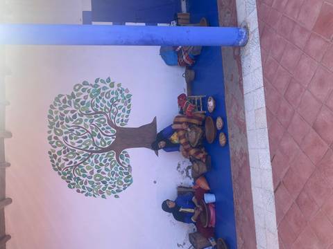 Two women sitting on the ground making traditional food.