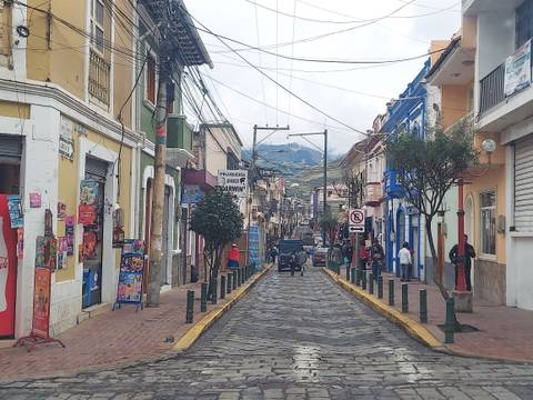 Busy street scene in Ecuador with colorful buildings and pedestrians.