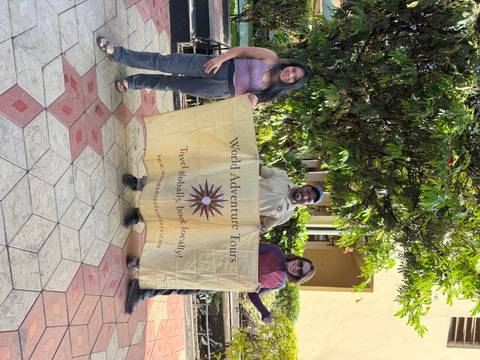       Group with a banner, posed in front of a building.
  
