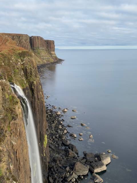 Cliffside waterfall cascading into the sea.