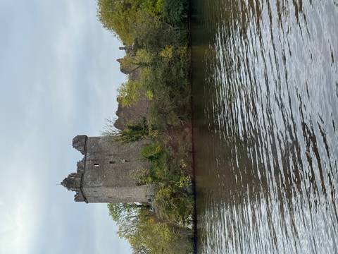 Ruins of a stone castle by a body of water.