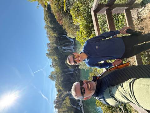 Two men posing in front of a cascading waterfall.