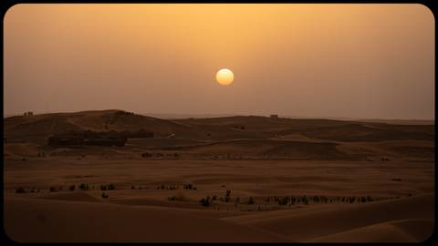      Sunset over a vast desert landscape.
  