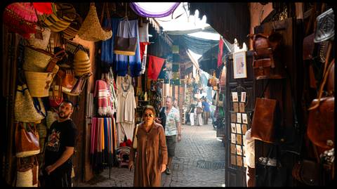 Tourists walking through a vibrant market street.