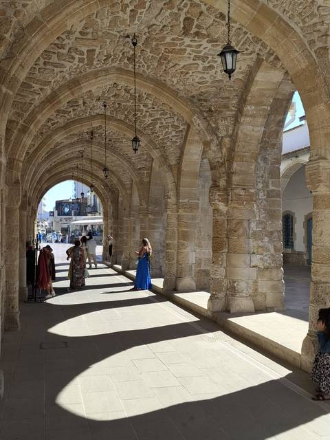 Stone arches with people walking underneath.