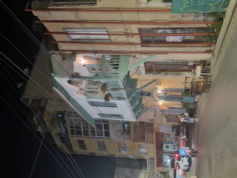 Street scene at night with a historic building.