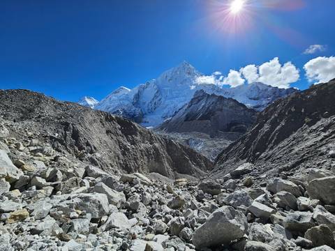 Rocky terrain leading to towering snow-covered mountains.