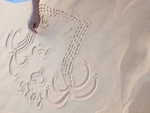 Arabic patterns drawn in the sand with a finger.