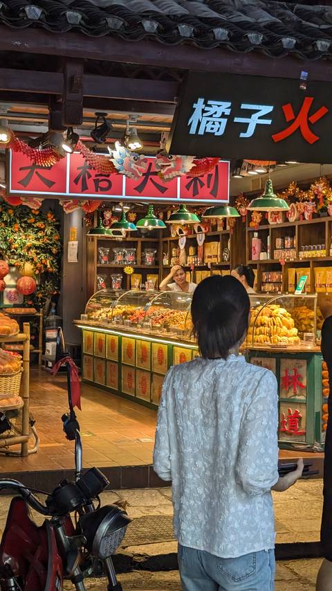       An indoor market with people shopping.
  