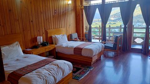       Interior view of a hotel room with wooden decor and a scenic view
  