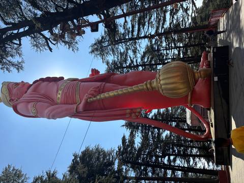 Large red statue of Hanuman against the sky