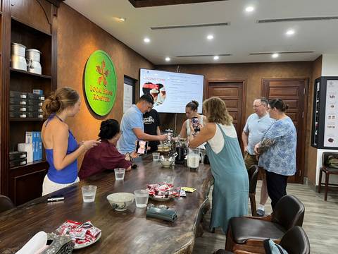 Group of people participating in a coffee-making class inside a café.