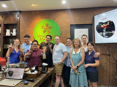 Group photo of people enjoying beverages inside a café.