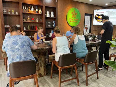 Participants seated at a table focusing on preparing beverages.