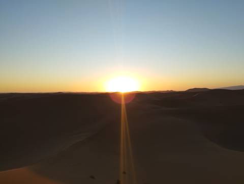       Sunset over desert dunes.
  