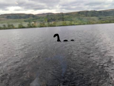       Wide view of a lake with an illustration of a mythical creature.
  