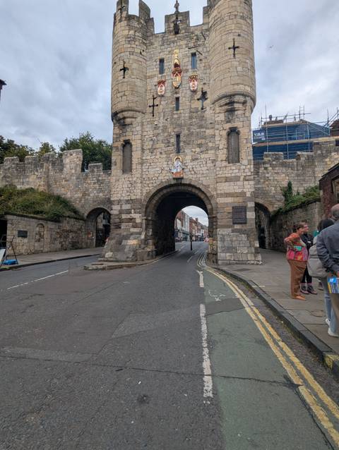       Historical stone gateway with people nearby.
  