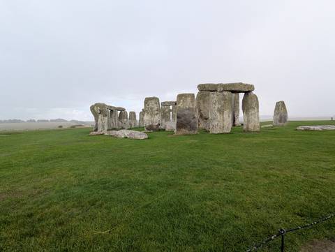       Stonehenge with lush green grass around.
  