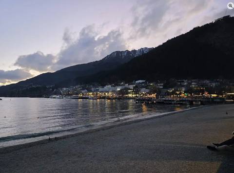       View of a town by a lake at dusk.
  
