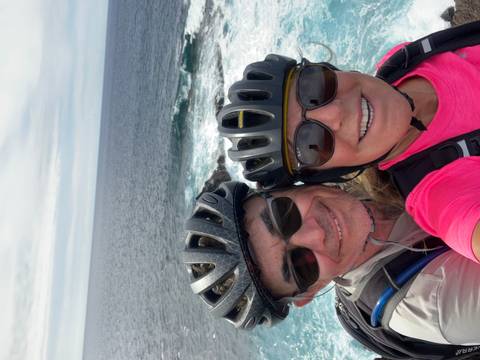       Two people taking a selfie with the ocean in the background.
  