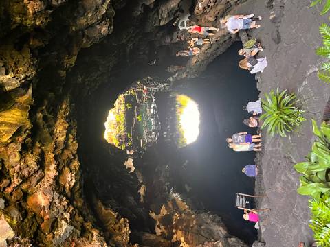       Cave exploration with water reflections and people.
  