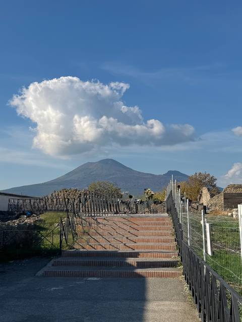       Mount Vesuvius with ruins and blue sky.
  
