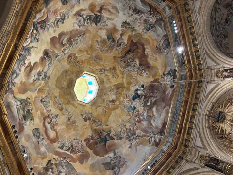       Intricate fresco ceiling with a central skylight.
  