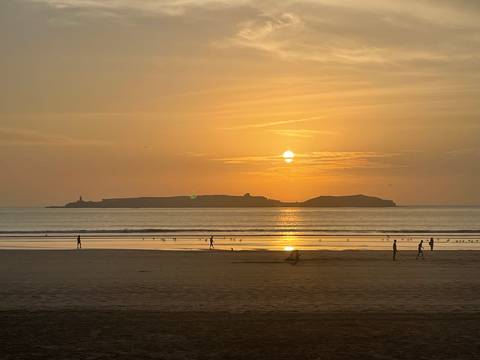 People on a beach during a golden sunset.