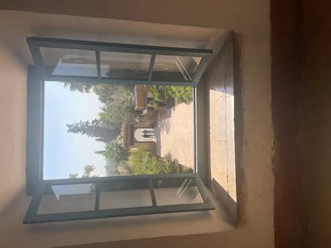       View through an open window showing two people and a garden path.
  