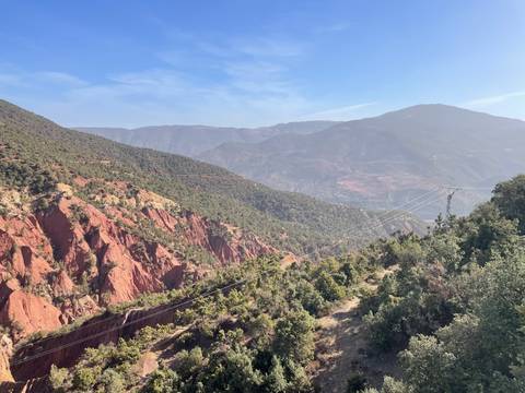       Mountainous landscape with greenery and rocky terrain.
  