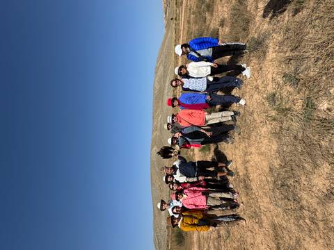 Group of people standing in a field with an eagle.