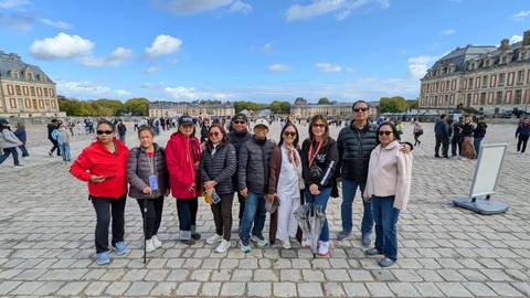 Group of people posing in a courtyard outside Versailles.