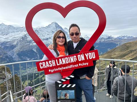 Couple with a heart-shaped frame and mountains in the background.