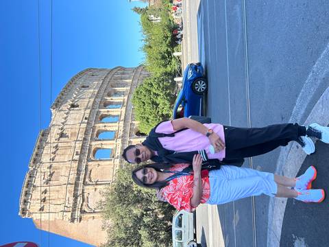 Couple standing with the Colosseum in the background.