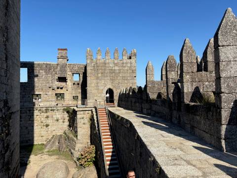       Stone-walled structure with lookout points under a blue sky.
  