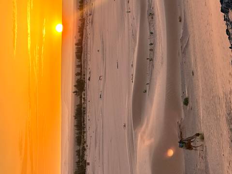       Sunset over sand dunes in the desert.
  
