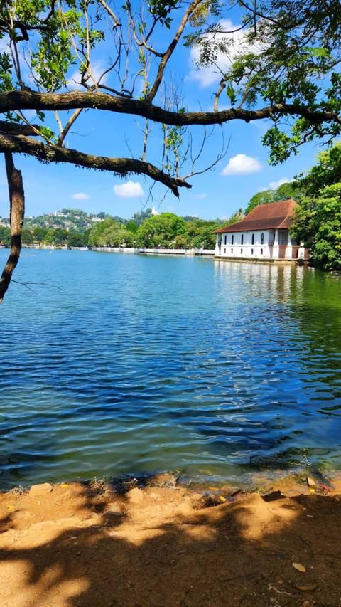 Lake with a building and hills in the background.