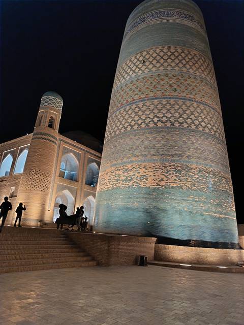       Historic building with arched windows and brickwork at night.
  