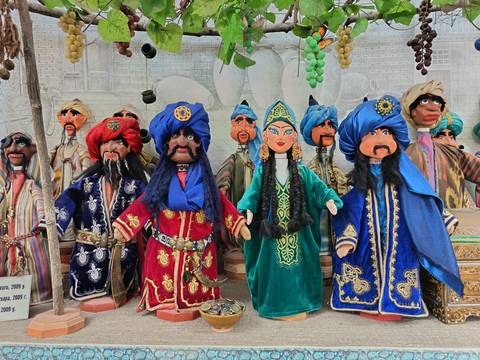       Colorful mannequins in traditional clothing on display.
  