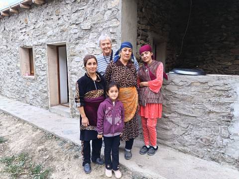      Family posing outside a stone house.
  