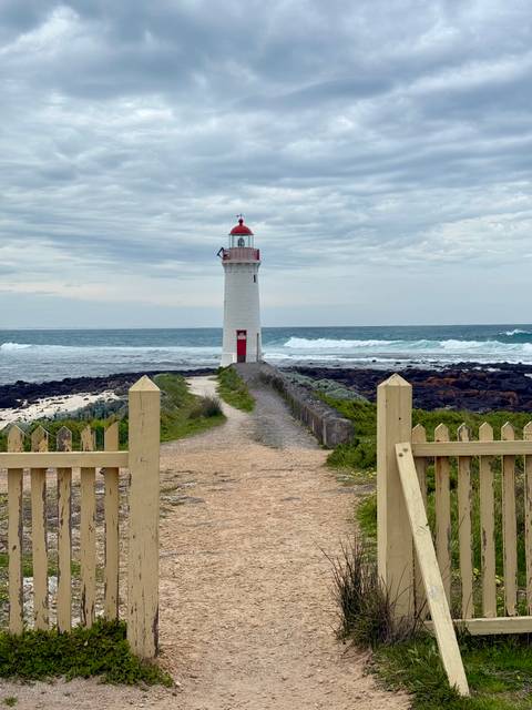       Lighthouse on a stormy day by the ocean.
  