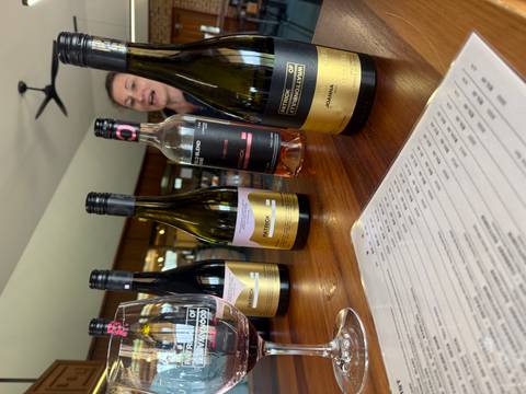       Bottles of wine displayed on a table with a person in the background.
  