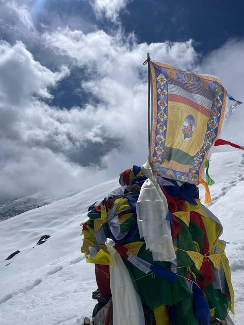       Prayer flags and snowy peaks in the backdrop.
  